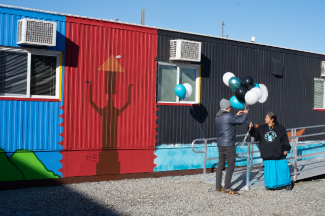Photo of people placing celebratory balloons at the Eagle Village opening