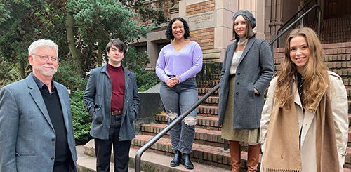 Five poeple standing on the steps of a university building