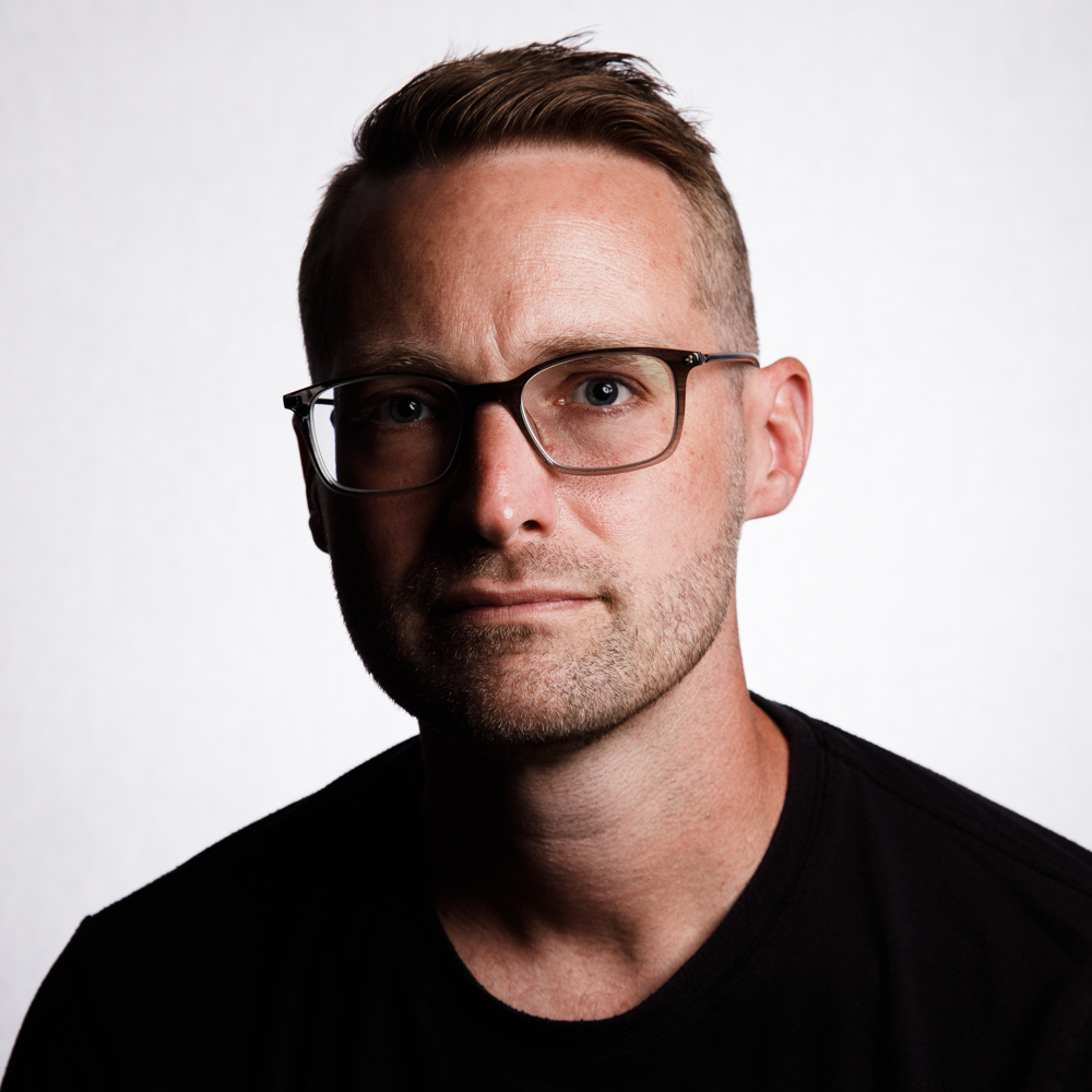 Headshot of man with glasses and short brown hair